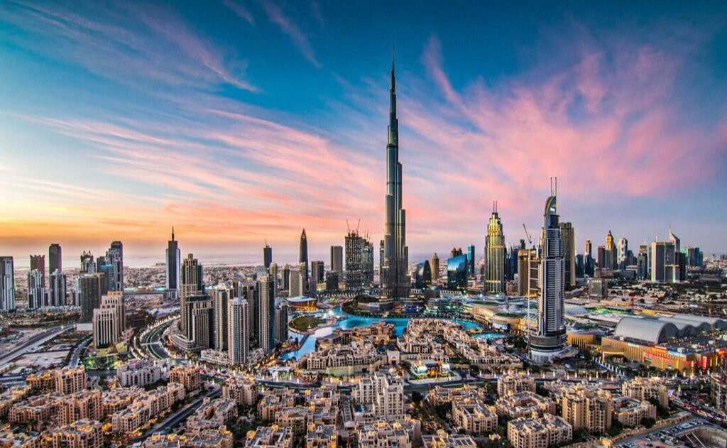 Panoramic view of Dubai's skyline at sunset, featuring the iconic Burj Khalifa surrounded by modern skyscrapers and vibrant city lights.