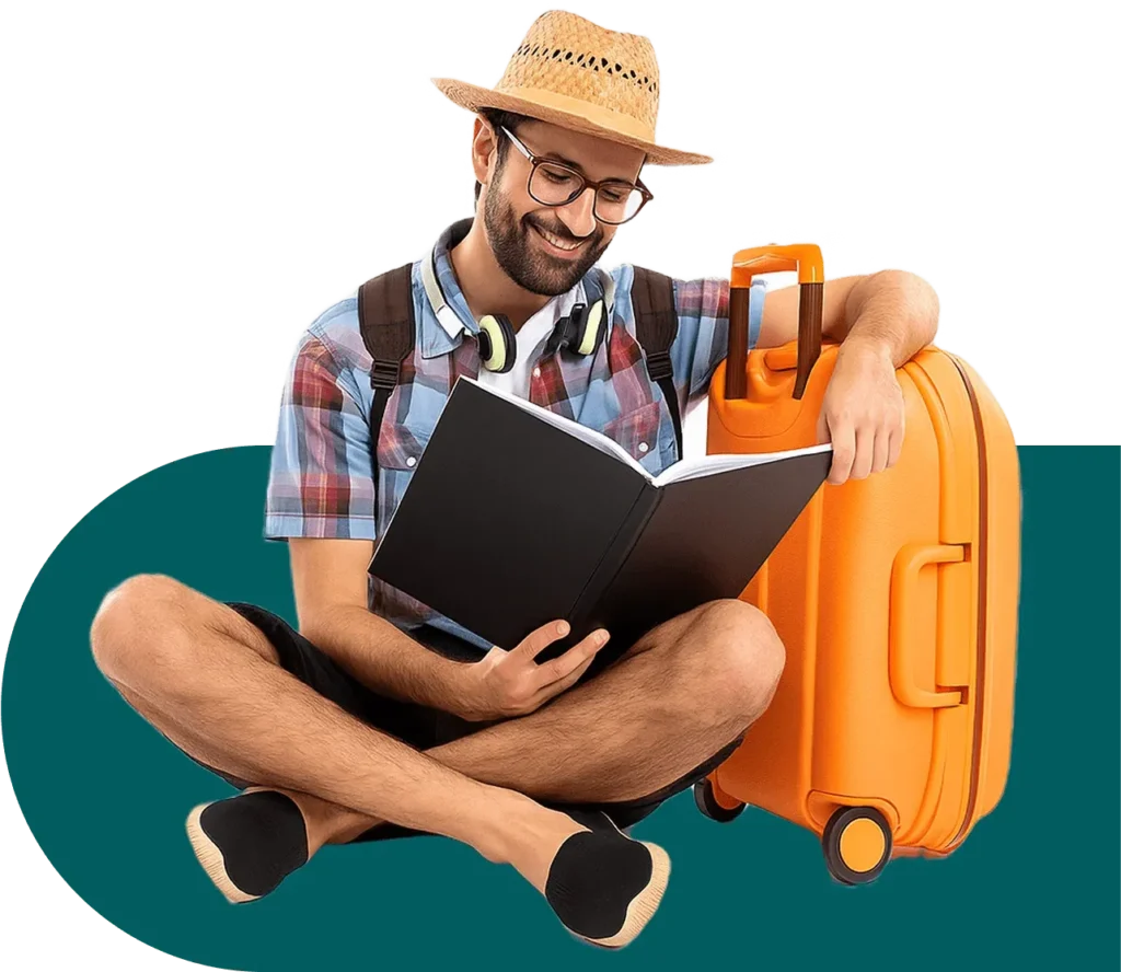 A traveler in a straw hat sits cross-legged beside an orange suitcase, reading a book with headphones on, embodying the spirit of adventure and relaxation.