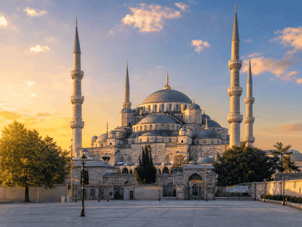 Sultan Ahmed Mosque, also known as the Blue Mosque, at sunset in Istanbul, Turkey, showcasing its iconic minarets and domes against a colorful sky.