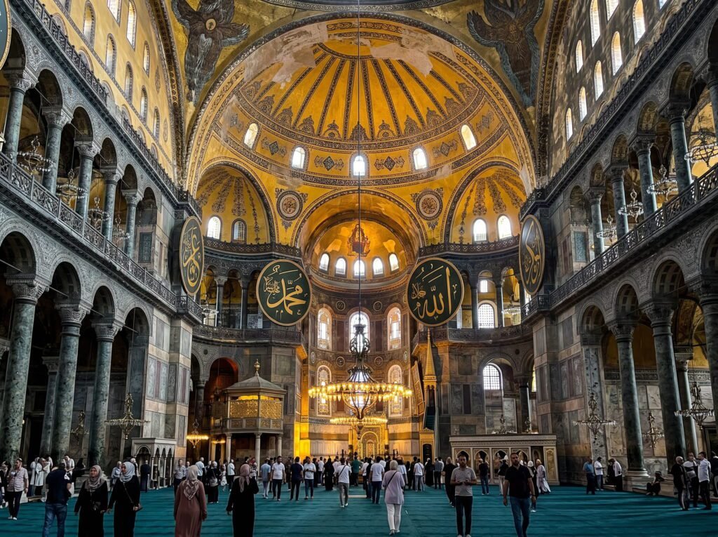 Interior view of the Hagia Sophia, showcasing its stunning architecture, large dome, and intricate mosaics. Visitors explore the space, which features prominent Arabic calligraphy and ornate chandeliers, highlighting its historical significance as a former cathedral and mosque.