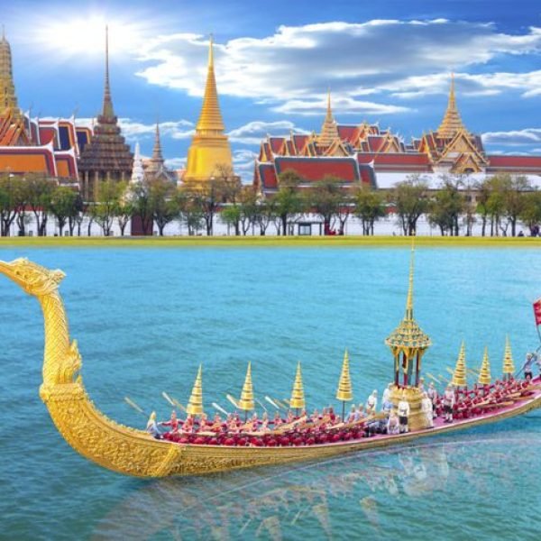 Royal barge procession on the Chao Phraya River in Bangkok, Thailand, with ornate traditional boats and the Grand Palace in the background, showcasing Thailand's rich cultural heritage and maritime traditions.