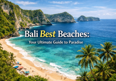 Aerial view of a stunning beach in Bali featuring turquoise waters, golden sand, and lush green cliffs, with beach umbrellas and people enjoying the sun, illustrating the beauty of Bali best beaches.