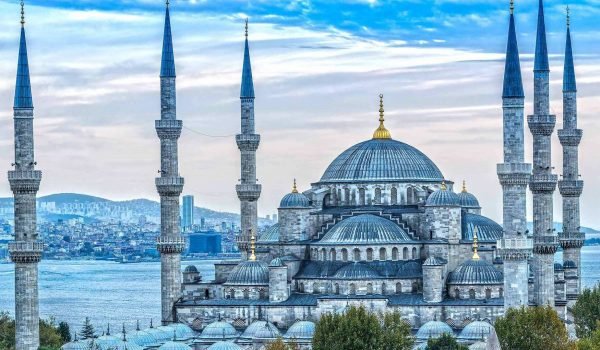 Blue Mosque in Istanbul, Turkey, featuring its iconic domes and minarets against a vibrant sky.